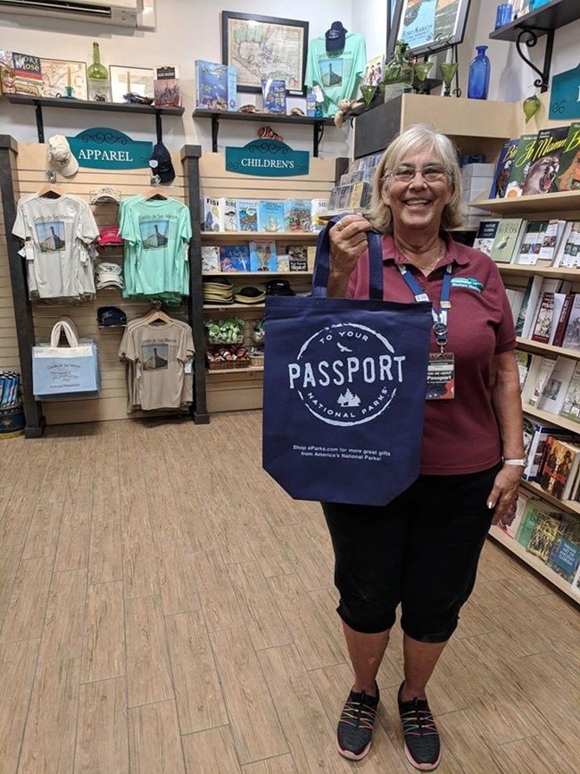 Eastern National Park Store Eastern National employee holding reusable bag in Park Store.