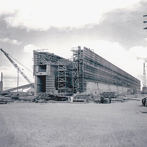 T Plant construction A black and white photo of a large, rectangular structure under construction. The structure is similar to an ocean liner’s hull.