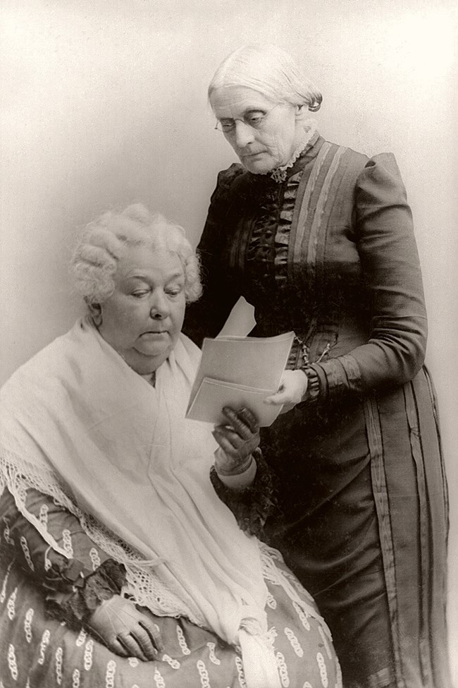 two elderly women looking at a book.