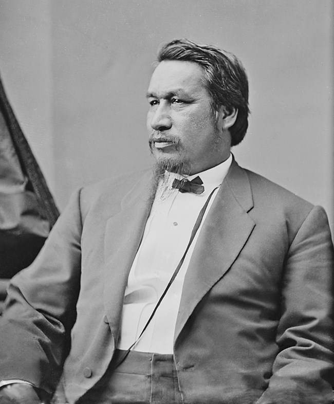 Black and white photo of a man in a suit facing left