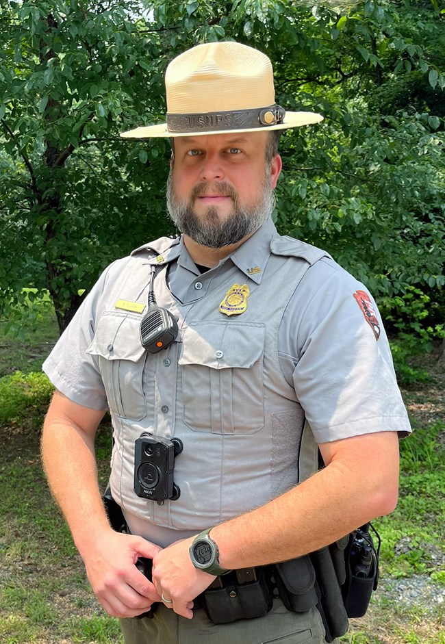 A uniformed person with a straw flat-brimmed hat.