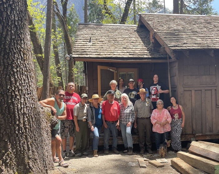 The Wilson Cabin a group of people pose in front of wooden cabin
