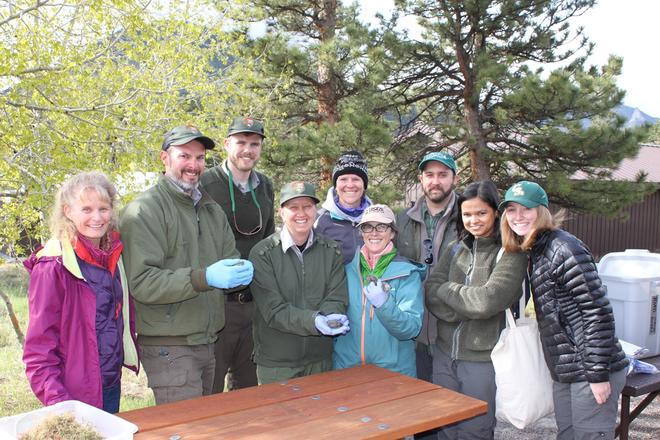 Erin Muth and group of researching posing for a photo holding boreal toads