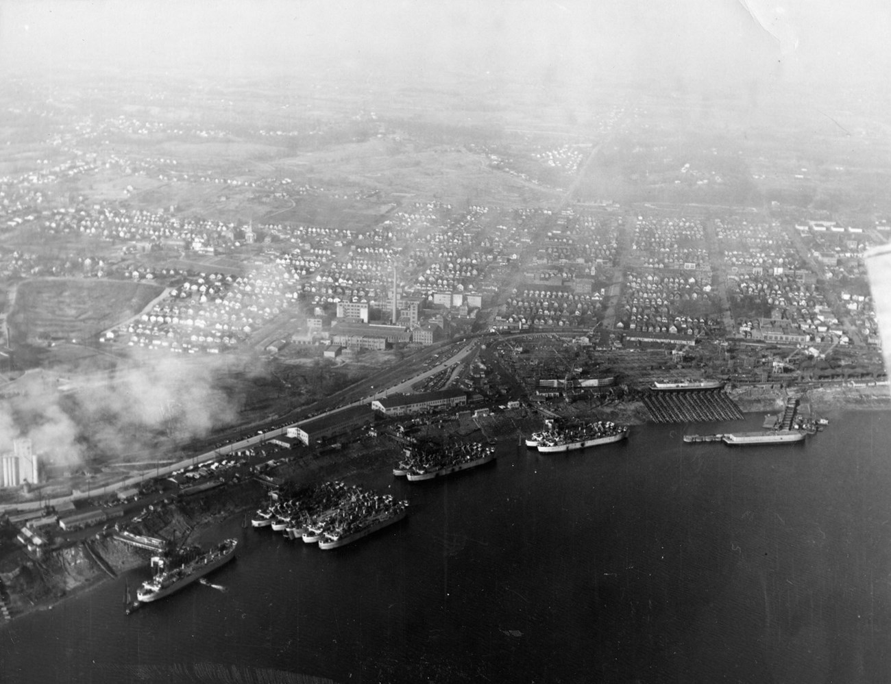 military ships in rows at docks on great lake