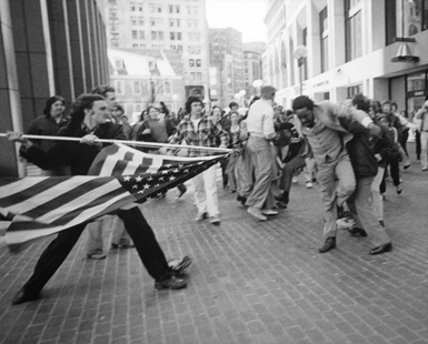 Violence against Black protestors at Government Center Plaza in Downtown Boston. A man wielding an American flag on the right