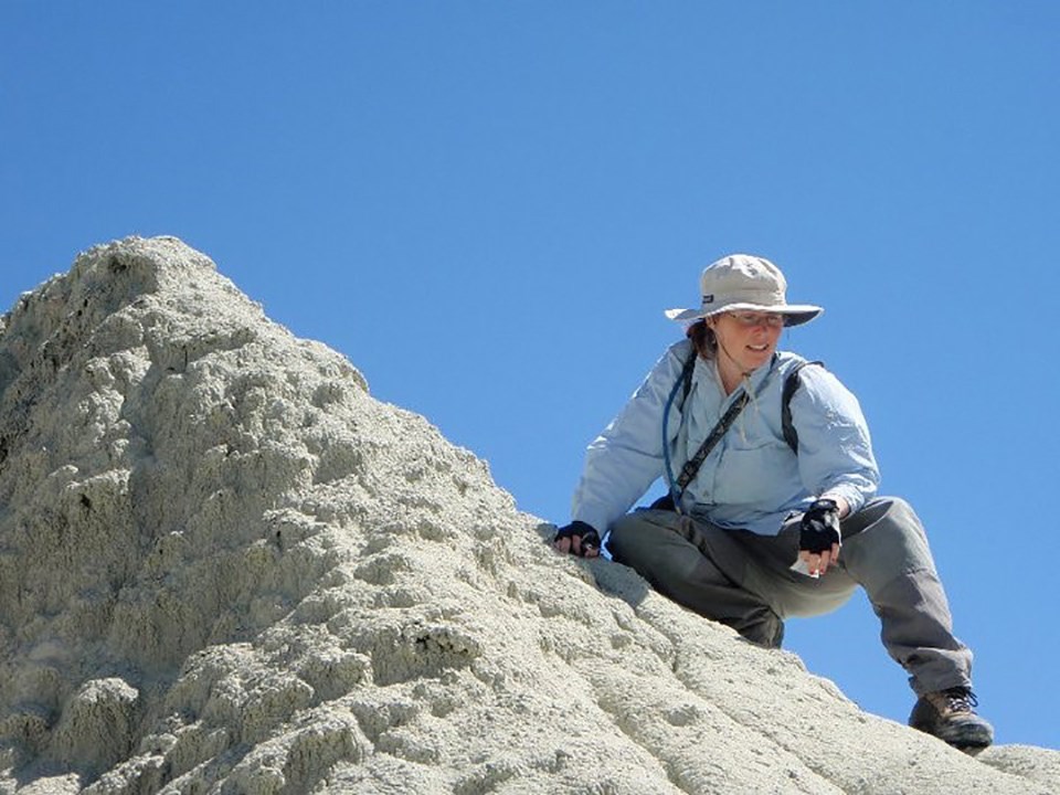 a person sitting on a high mud hill