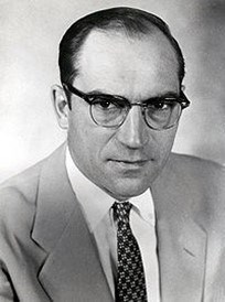 Photo of a man wearing a suit and glasses.
