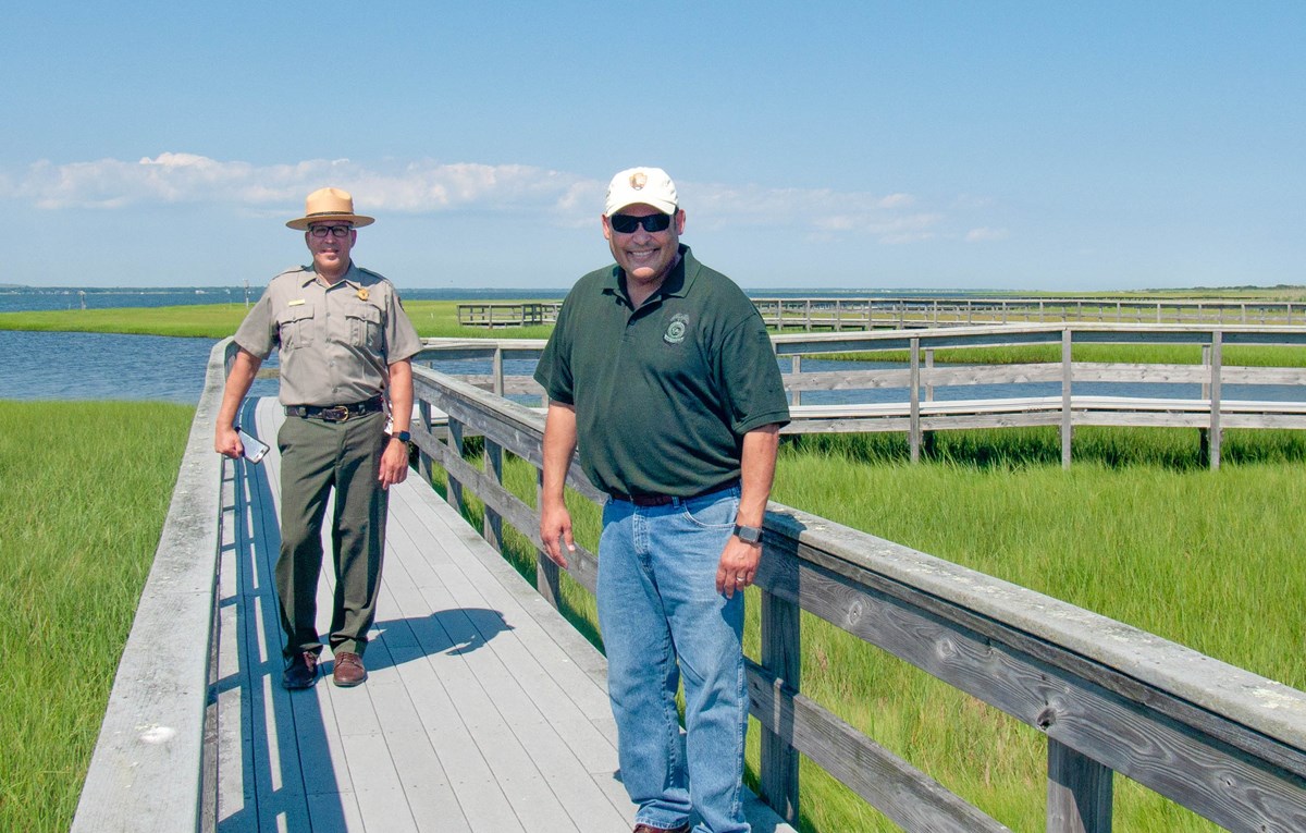 Superintendent Alex Romero and Deputy Director David Vela on a boardwalk over a marsh