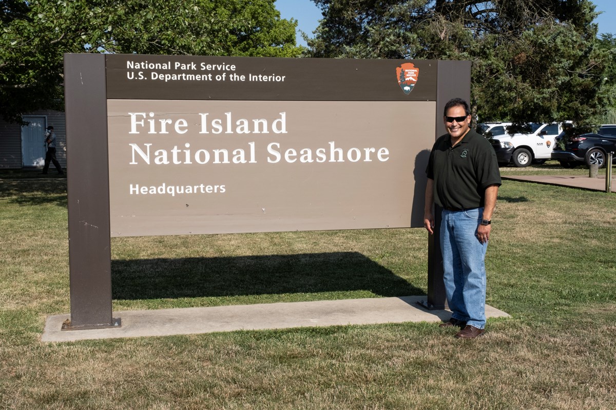 David Vela standing at an entrance sign for Fire Island National Seashore