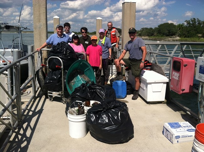 Group of volunteers who helped cleanup the beach by collecting bags of trash.