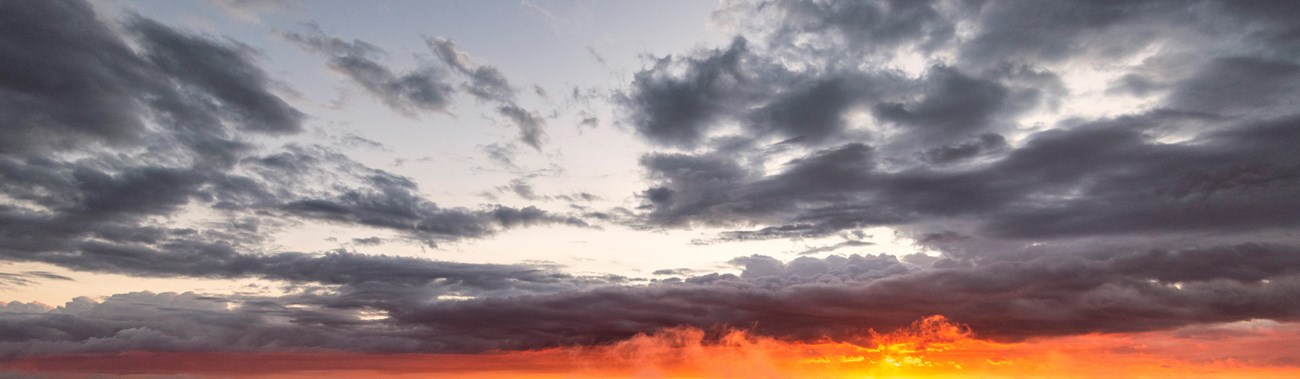 Dark clouds above an orange sunrise. Dark clouds above an orange sunrise.