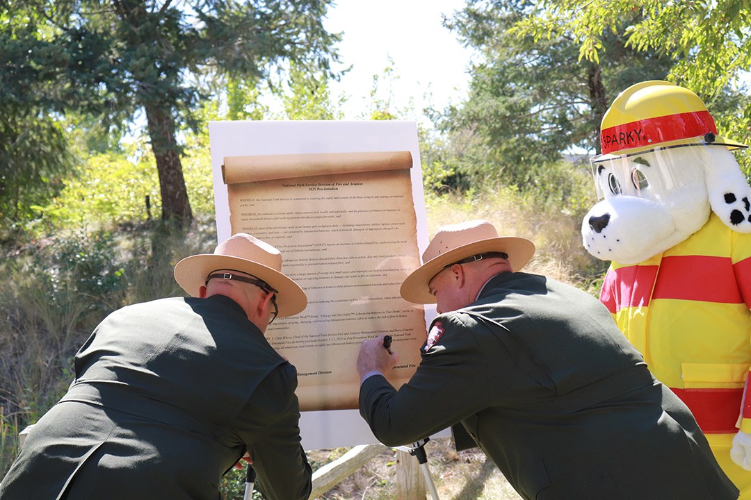 Fire chiefs sign the poster-sized proclamation to recognize fire prevention week.