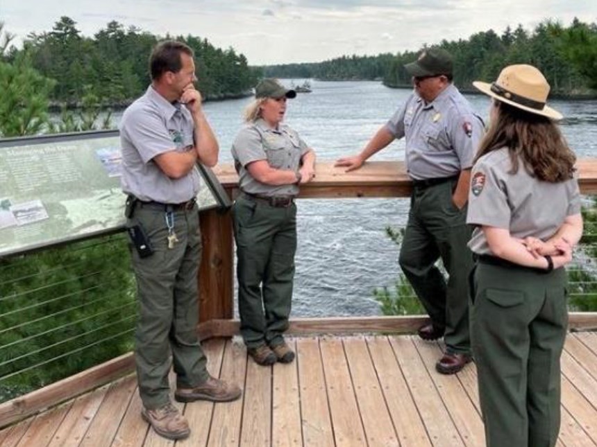 Photograph of people standing on an overlook talking.