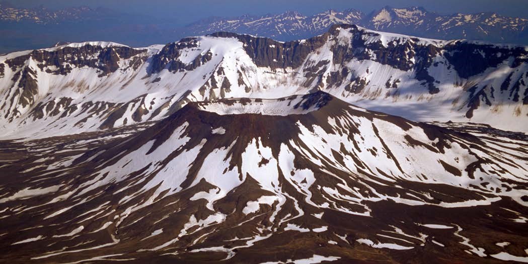 volcanic crater and portion of caldera rim with partial snow cover