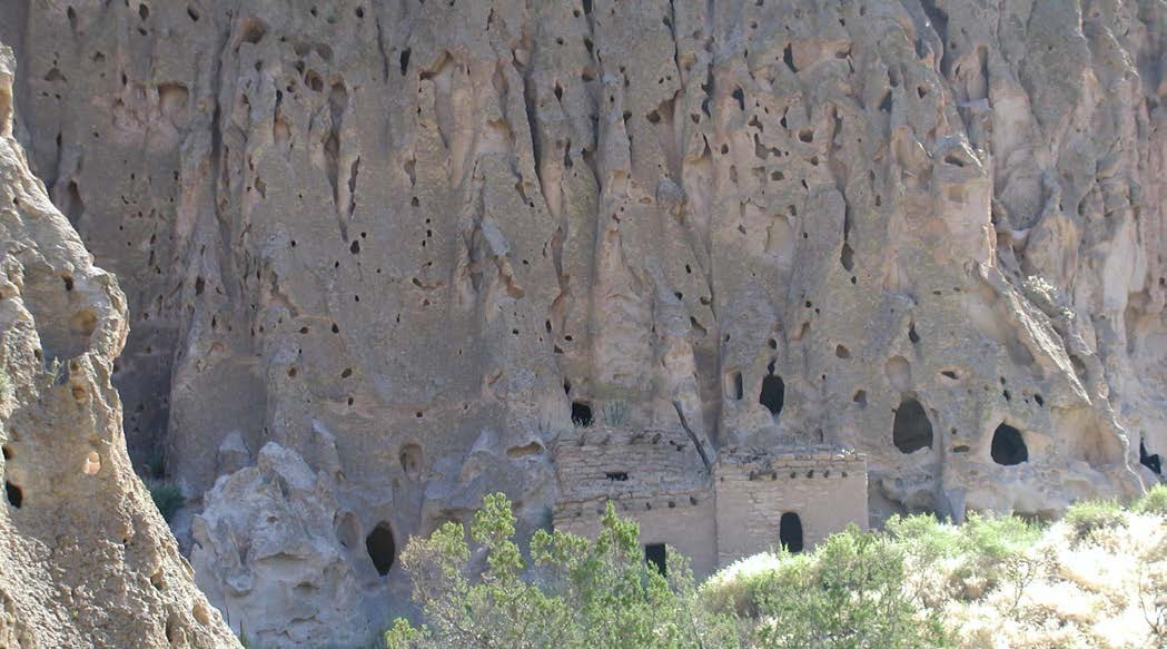 Photo of cliff with carved windows and doors.