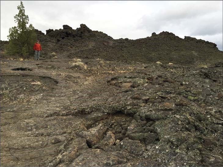 photo of a person standing on lava rock