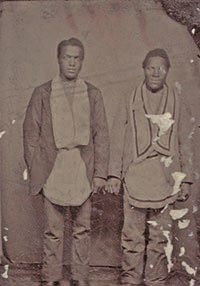 Black and white photo of two standing Black men wearing ceremonial garb