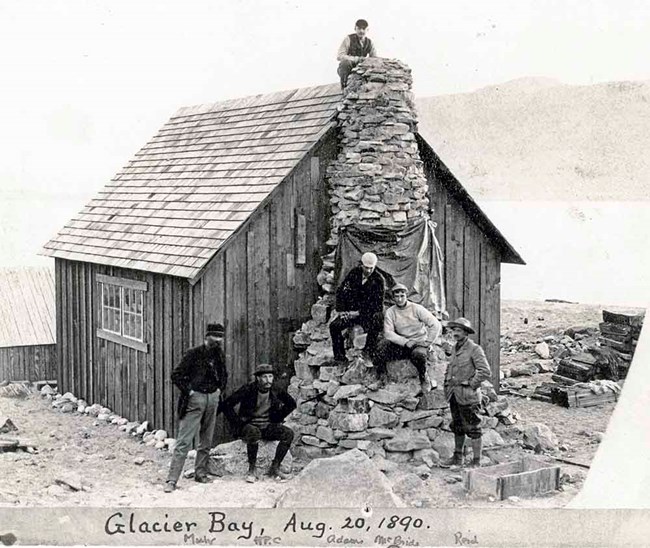 Historic image of a cabin and men in Glacier Bay.