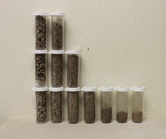 lt= series of vials with different sizes of soil material