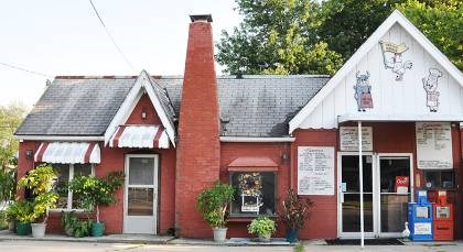 Red brick building with restaurant menus near the glass entrance doors.