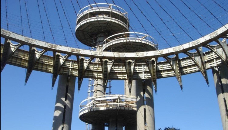 Looking up; isosceles triangles lining part of circular roof support; 3 observation platforms in background.