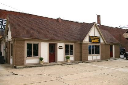 Building with brown roof, brown siding, and tan trim.