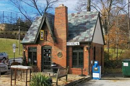 Red brick building with multicolor roof and sign for coffee shop.