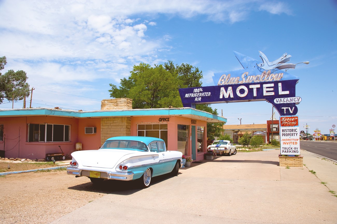 A neon hotel sign: a larger than life blue bird above text reading Blue Swallow Hotel.