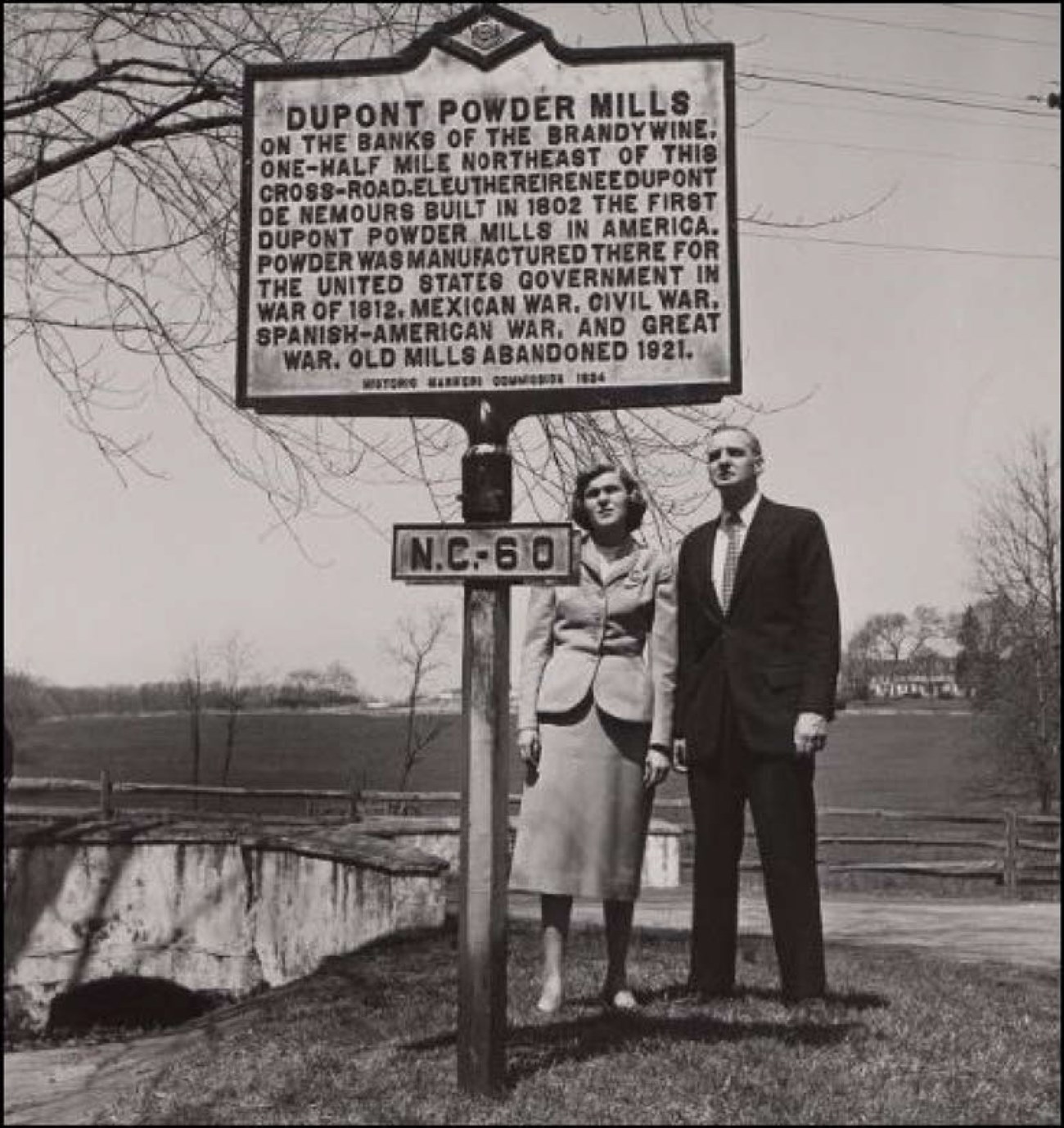 DuPont Powder Mills Historical Marker Man and woman reading Dupont Powder Mills historic roadside marker N.C. – 60. Countryside in background.