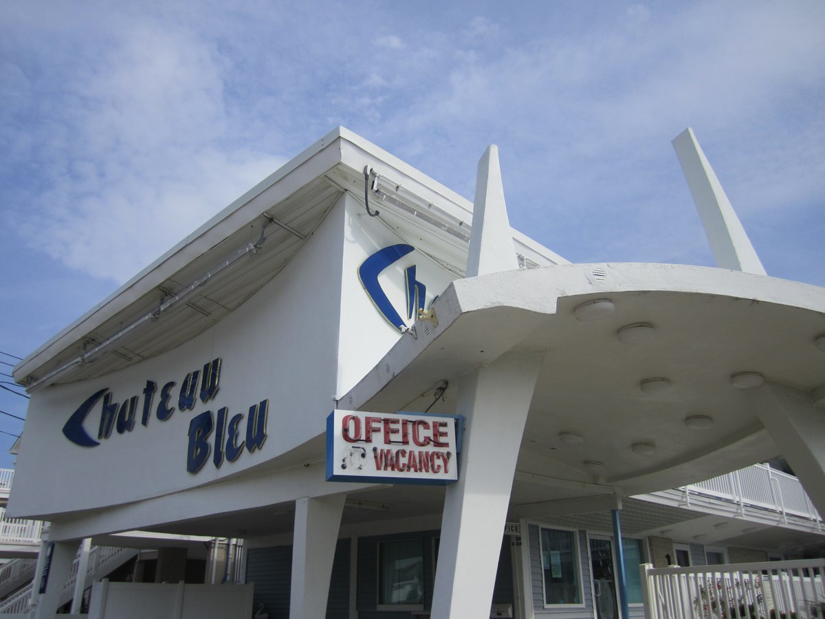 Chateau Blue White mid-century modern motel covered entry sign reads Chateau Blue Office Vacancy.