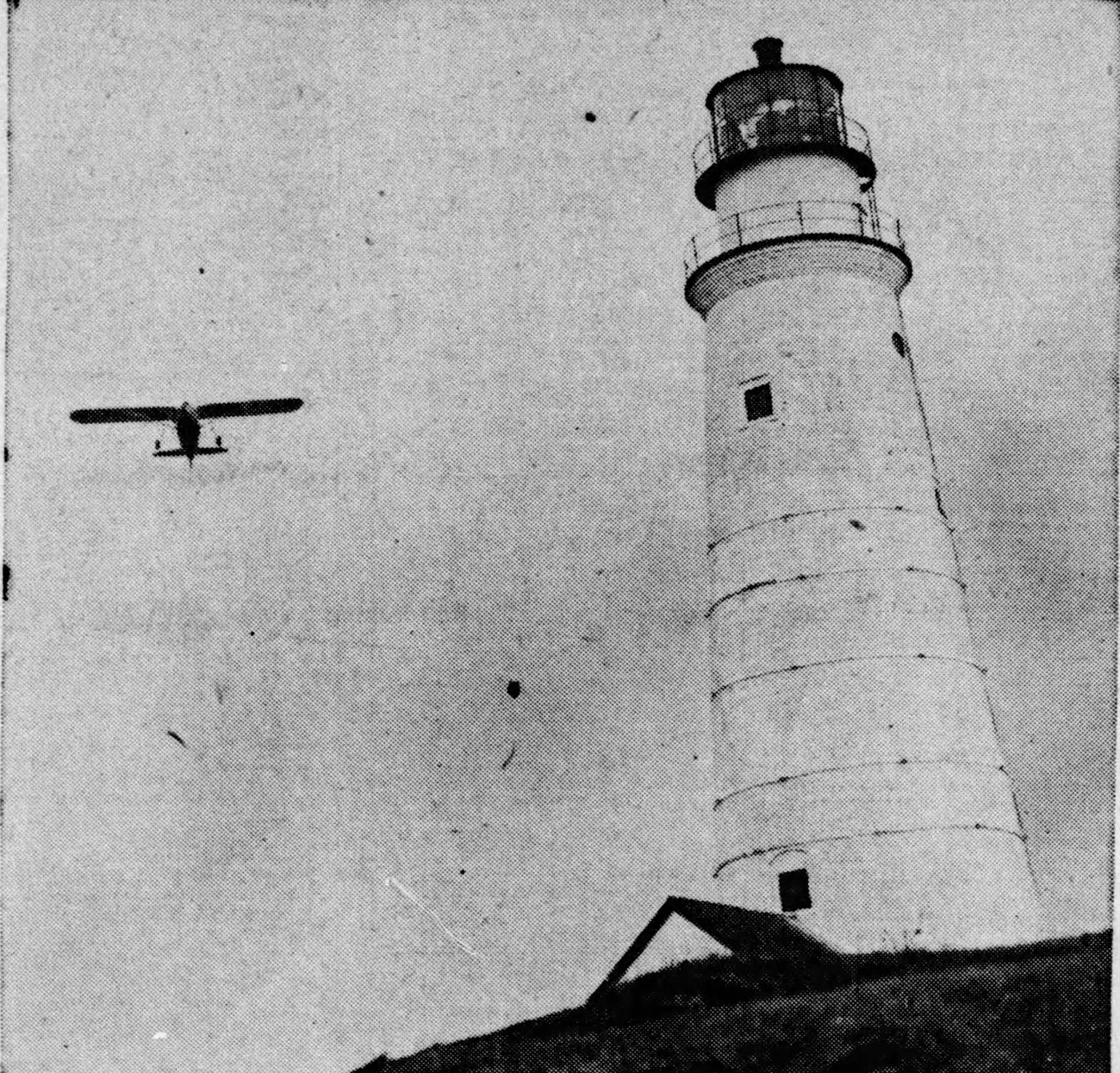 FlyingSantaBostonLight_SpringfieldDailyRepublican_Dec261939-cropped Boston Light, a white lighthouse, stands tall as a plane flies nearby