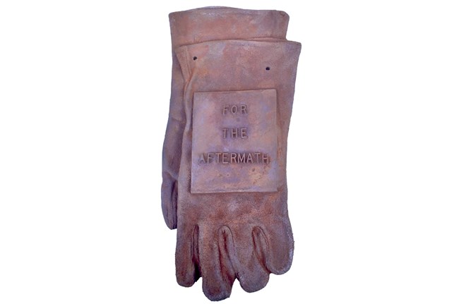 A pair of gloves in cast iron with "For the Aftermath" on them A pair of gloves in cast iron with "For the Aftermath" on them