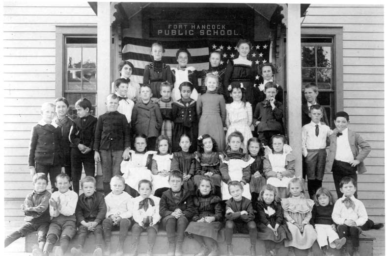a group of young children sit on school house steps
