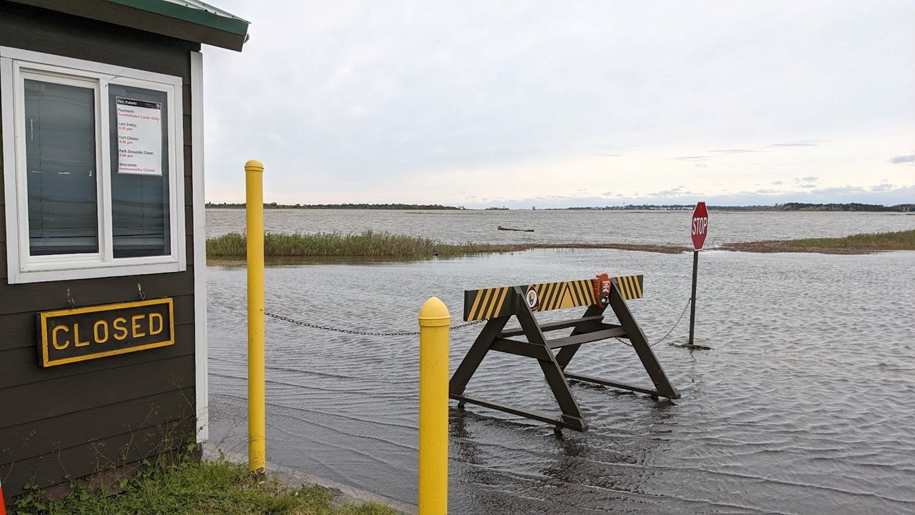 a flooded road with a roadblock structure