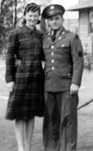 a man in a military uniform stands beside a woman in a dress