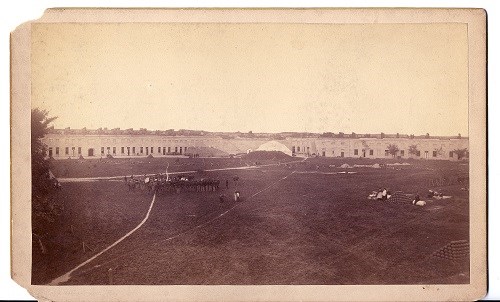 View from parade grounds. Guns are visible on the ramparts, a lot of people arounmd the parade grounds. Some are practicing things, others are sitting.