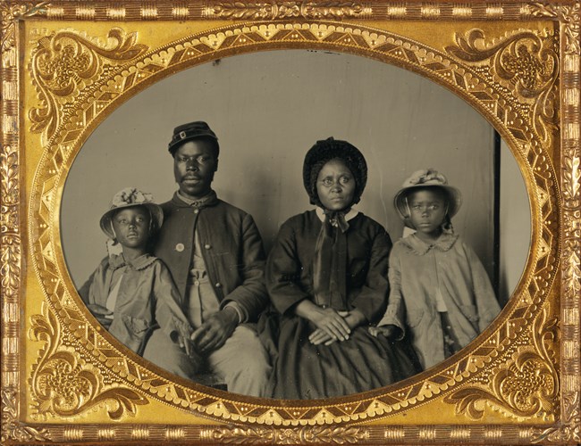 USCT Soldier posing for photograph with his family in a seated position