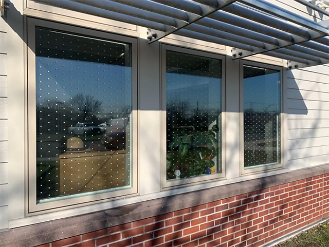 Gateway visitor center Bay of three windows, each covered in perfectly spaced patterns of small white squares.