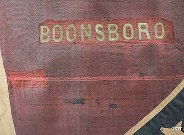 "Boonsboro" battle honors 2nd N.C. flag The word "Boonsboro" seen in yellow on a red fabric background with part of a blue section of fabric intersecting the bottom right corner.