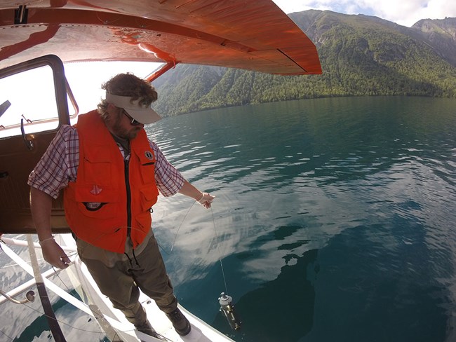 GOPR3820_web A fisheye view of a researcher taking lake samples from the float of a plane.