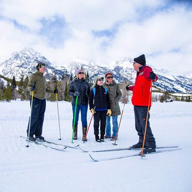Ski ambassador chats with park visitors on the groomed Teton Park Road in Grand Teton National Park