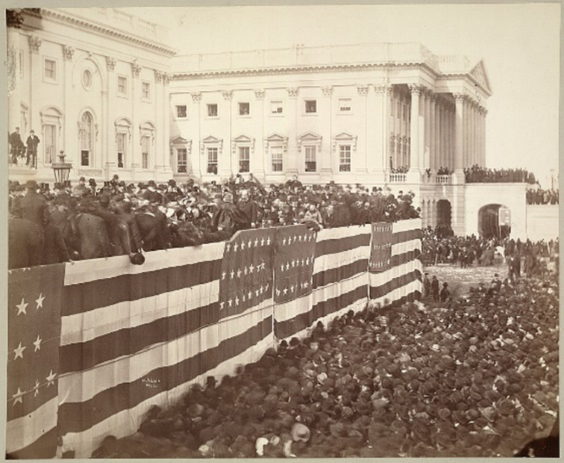 sepia tone image of Garfield standing in front of a large gathered crowed in Washington D.C. for his inauguration