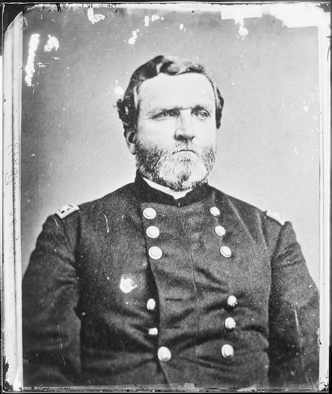 Black and white portrait of a man looking off into the distance, while wearing a civil war uniform