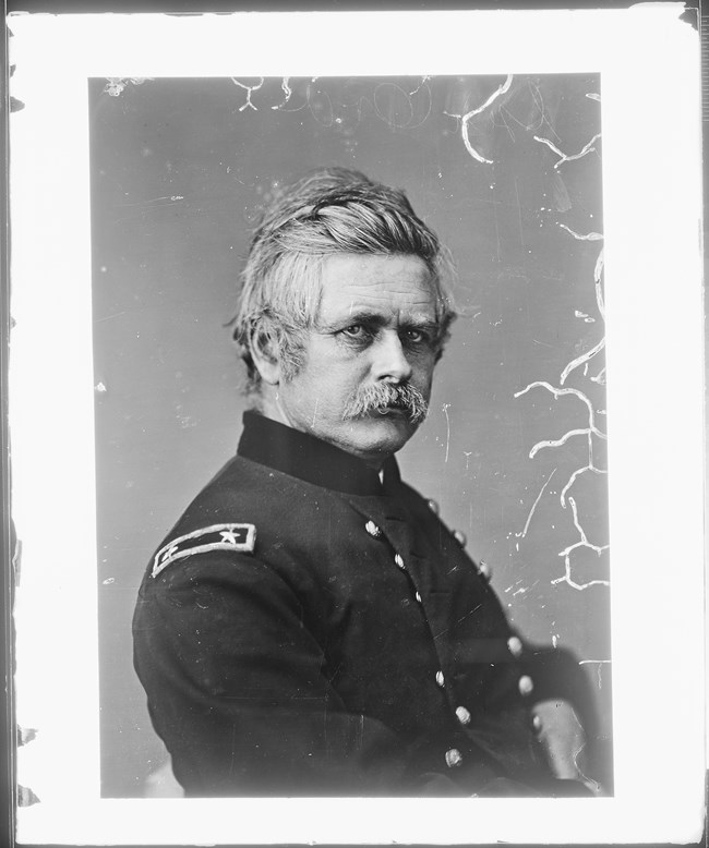 Black and white photo of a man in a civil war uniform facing right