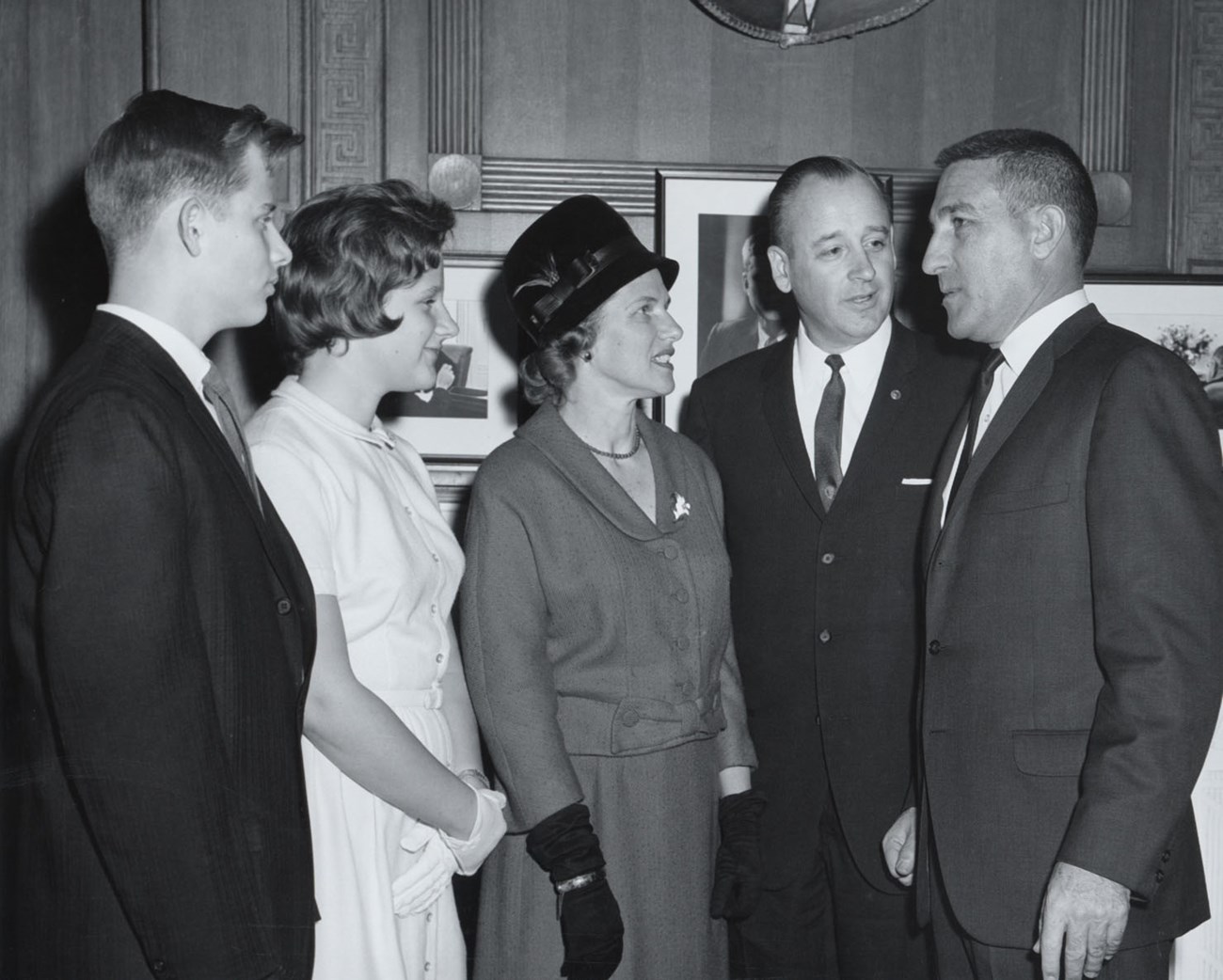 The Hartzogs and Steward Udall Four Hartzogs stand next to Steward Udall inside an office