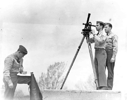 three young soldiers in uniform prepare to launch a weather balloon
