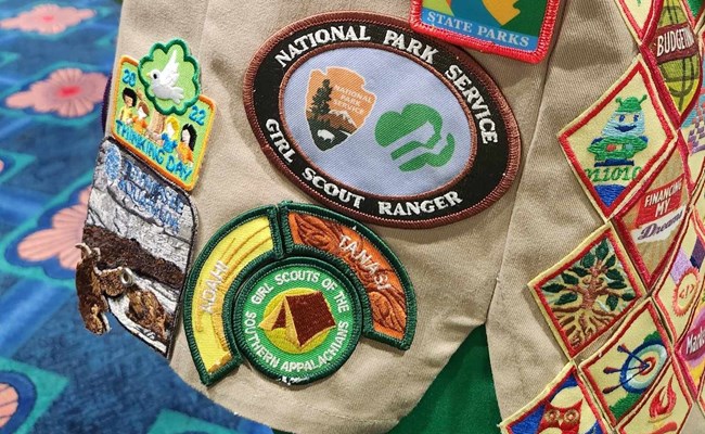 Girl Scout Ranger Patch on vest A display of various colorful Girl Scout patches on a khaki vest.
