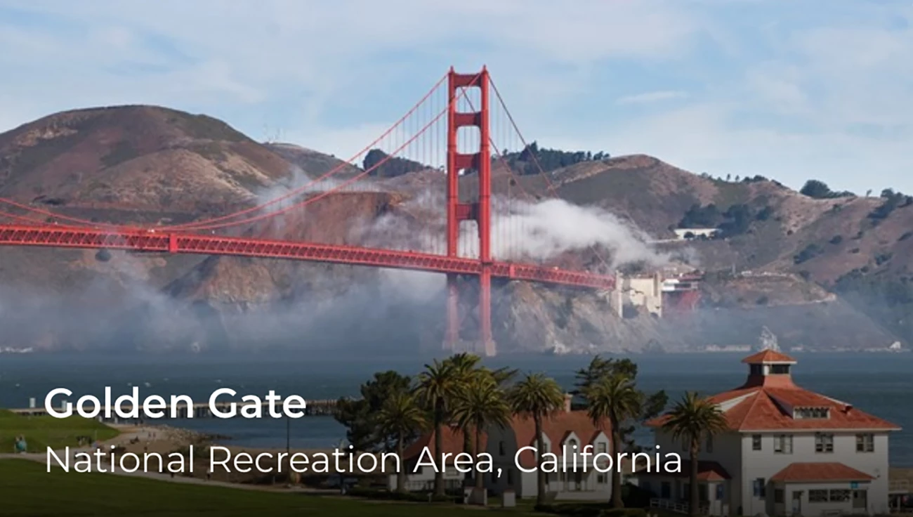 A red bridge spans over fog with hills in the background. On the lower left words say, Golden Gate.