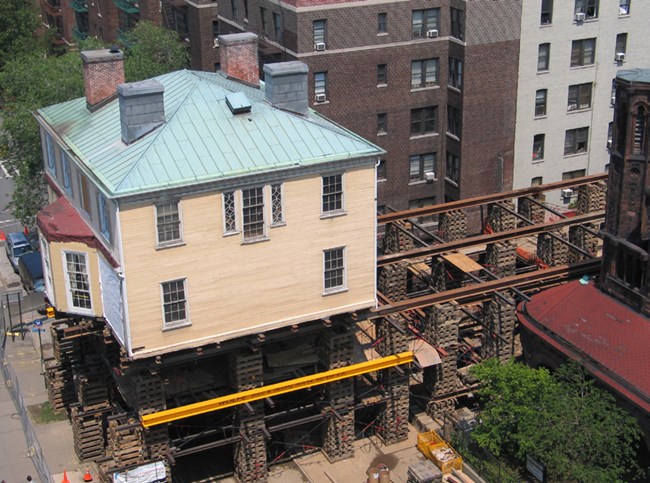 The Grange rises above the street, propped up by many pieces of lumber.