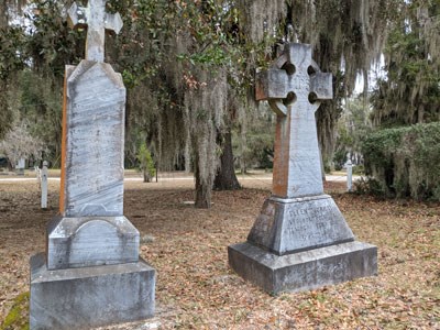 Two grave stones situated underneath live oak trees